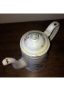 Old coffee maker in white enamelled sheet metal with floral decoration in relief