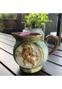 Old small pitcher in dabbling lion decor