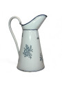 Old enamelled sheet metal pitcher with blue floral decoration on a white background