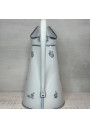 Old enamelled sheet metal pitcher with blue floral decoration on a white background