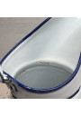 Old enamelled sheet metal pitcher with blue floral decoration on a white background